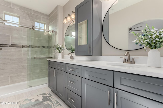 bathroom with vanity, hardwood / wood-style flooring, and a shower with door