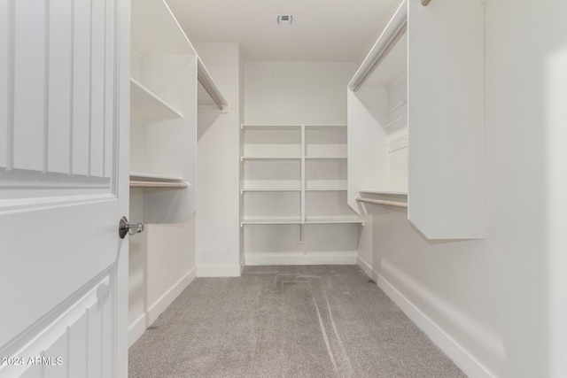 walk in closet featuring light carpet