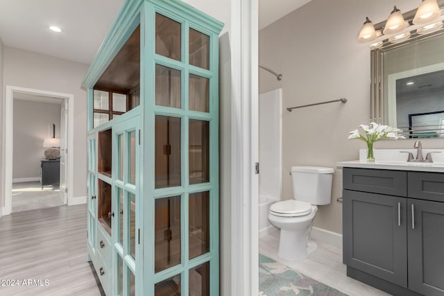 full bathroom with hardwood / wood-style floors, vanity, toilet, and shower / washtub combination