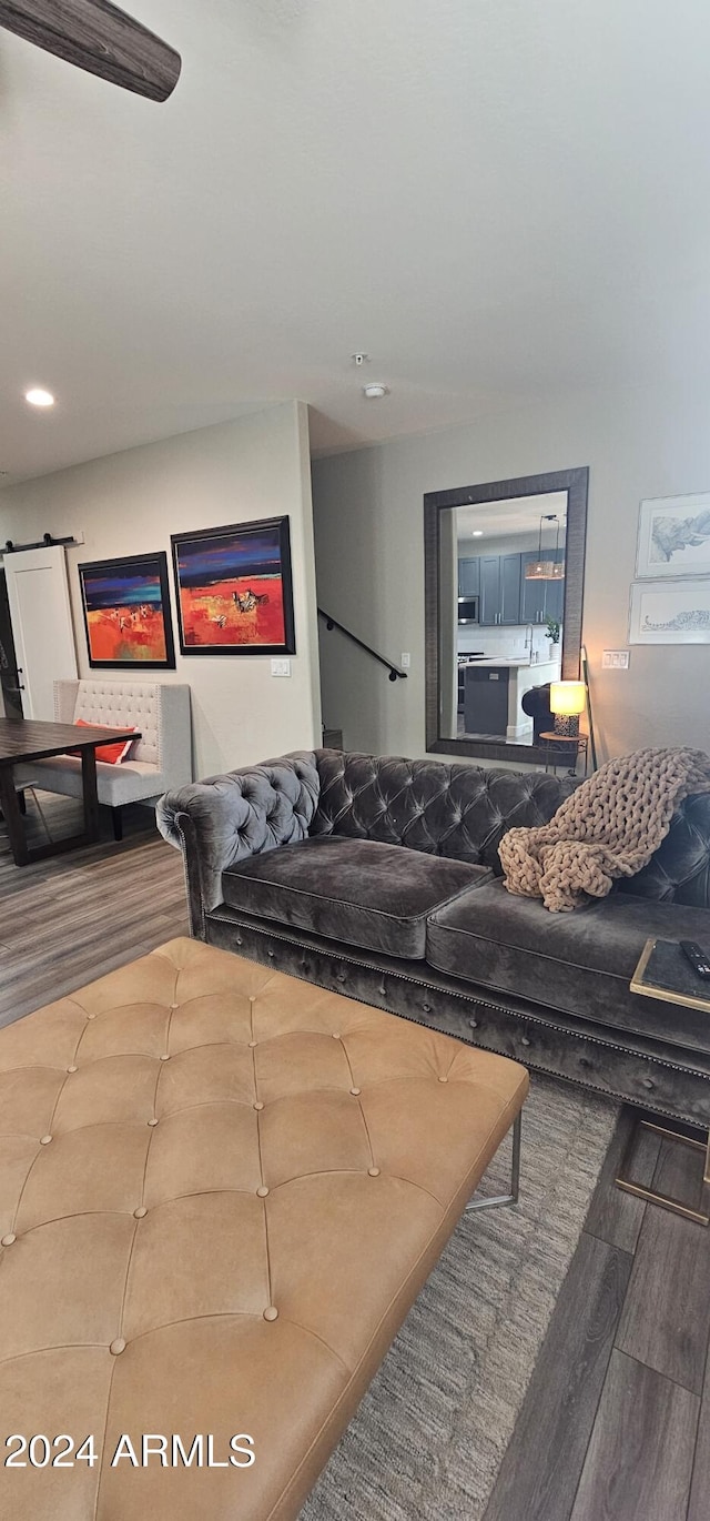 living room with a barn door and hardwood / wood-style flooring