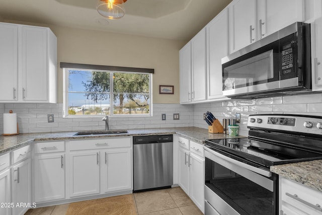 kitchen featuring appliances with stainless steel finishes, light stone countertops, and white cabinets