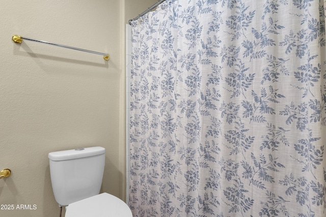 bathroom featuring walk in shower and toilet