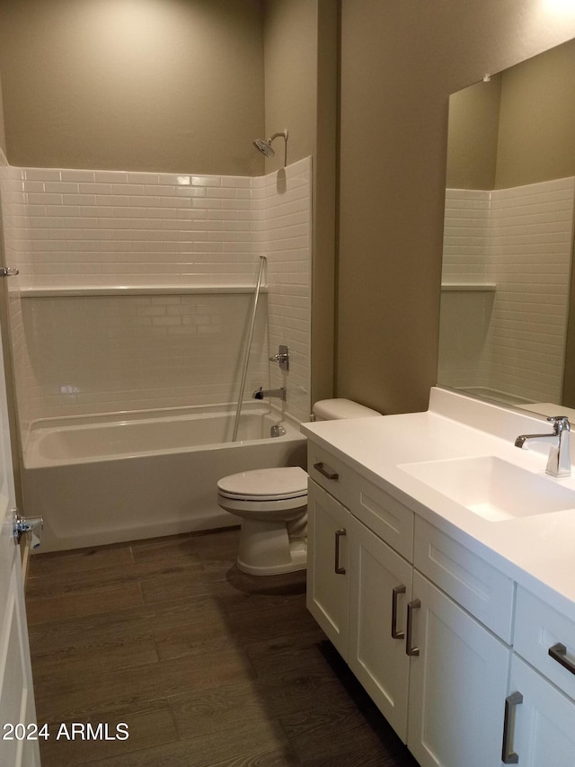 full bathroom featuring washtub / shower combination, toilet, vanity, and hardwood / wood-style flooring