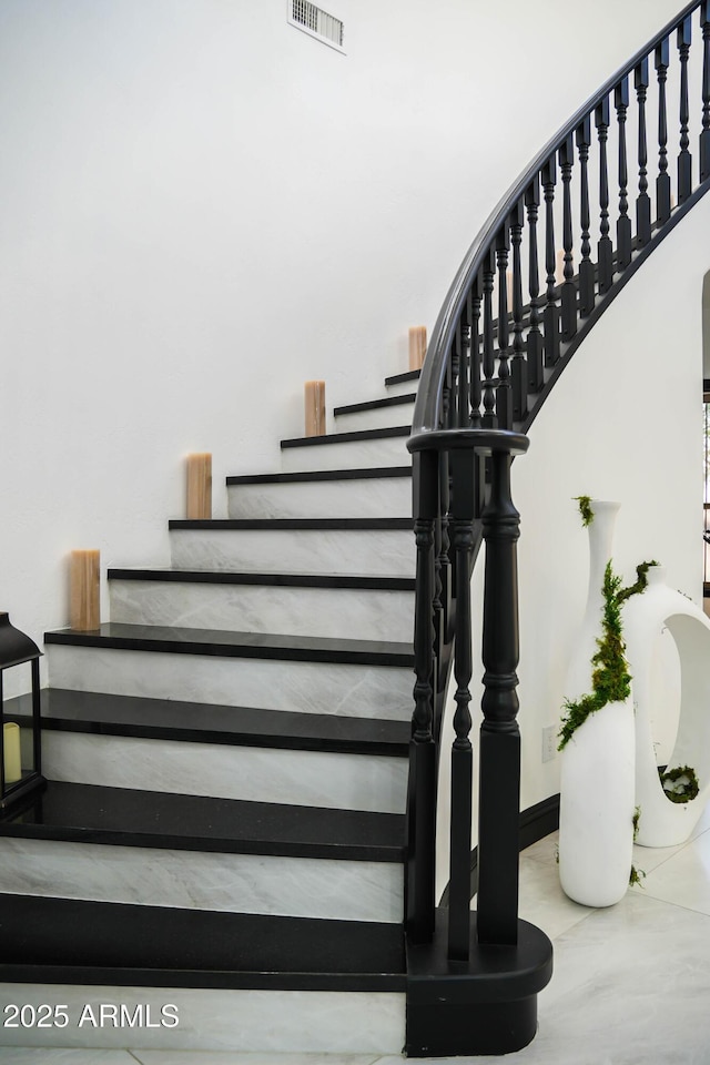 stairway with baseboards and visible vents