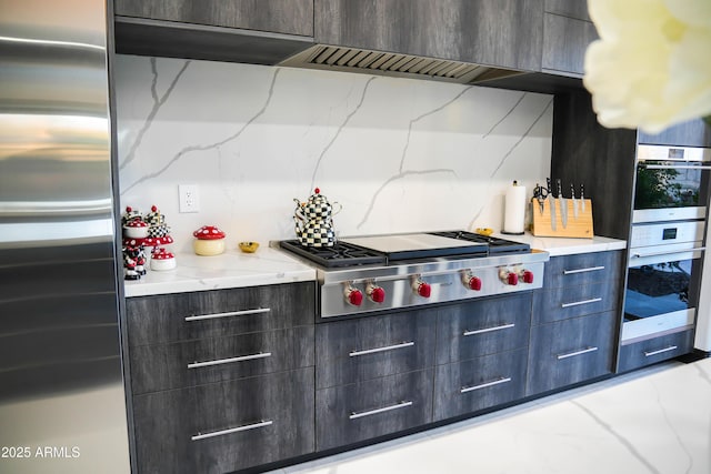 kitchen featuring light stone countertops, modern cabinets, and appliances with stainless steel finishes