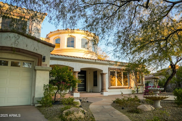 view of front of home with an attached garage, stucco siding, and a tiled roof