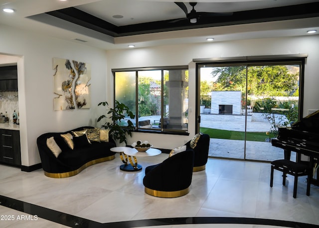 living room with a raised ceiling, visible vents, and recessed lighting