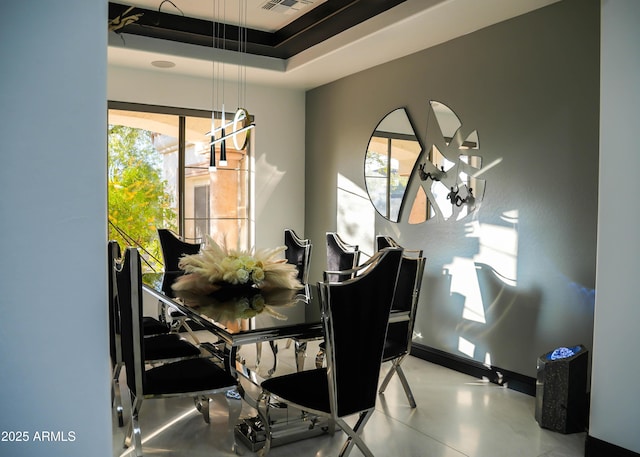 dining room with baseboards and a raised ceiling