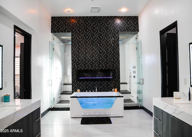 full bathroom with a tile fireplace, tile patterned flooring, two vanities, a freestanding bath, and a stall shower