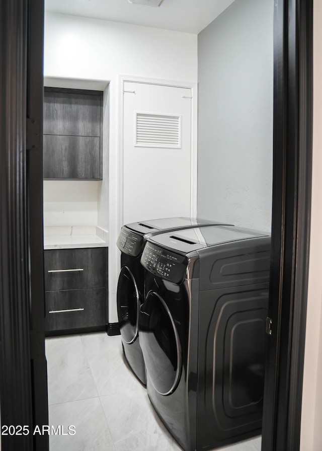 laundry area featuring washing machine and dryer, laundry area, and light tile patterned floors