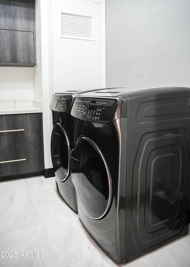 laundry area featuring light tile patterned floors, laundry area, and washer and dryer