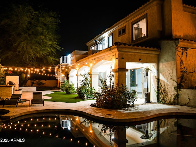 patio at night with an outdoor pool