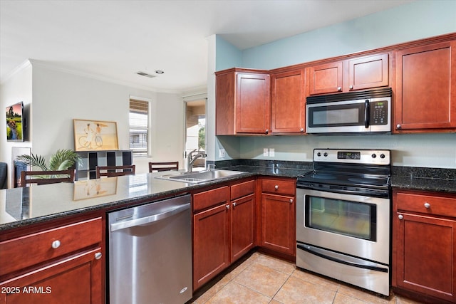 kitchen featuring stainless steel appliances, dark stone counters, sink, ornamental molding, and light tile patterned floors