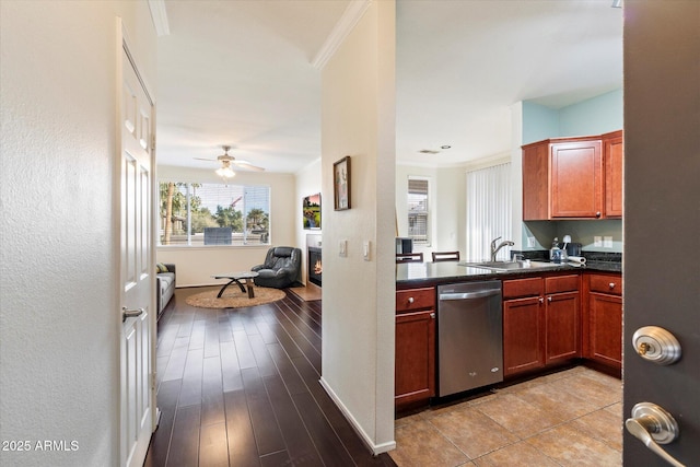 kitchen with dishwasher, dark countertops, open floor plan, crown molding, and a sink