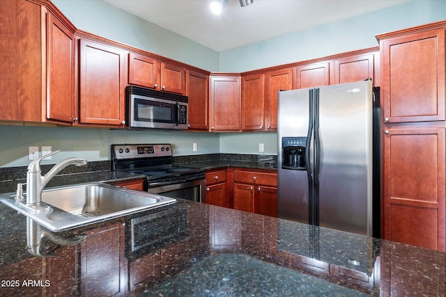 kitchen featuring sink, stainless steel appliances, and dark stone counters