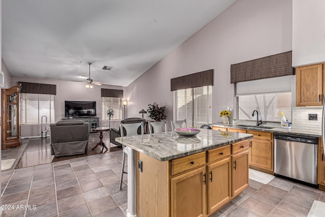 kitchen with dishwasher, high vaulted ceiling, sink, ceiling fan, and a kitchen island