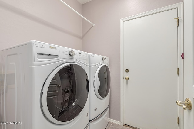 laundry area with light tile patterned floors and washer and dryer