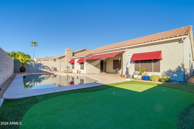 rear view of property with a patio area and a fenced in pool