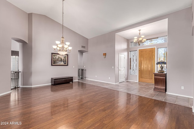 foyer entrance featuring dark hardwood / wood-style floors, high vaulted ceiling, and a chandelier