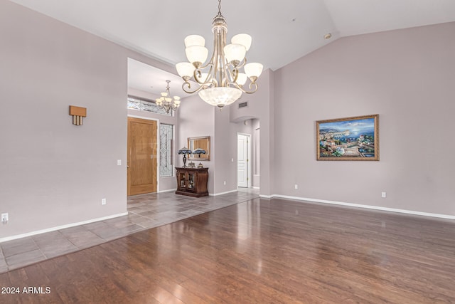 unfurnished living room featuring a notable chandelier, dark hardwood / wood-style flooring, and vaulted ceiling