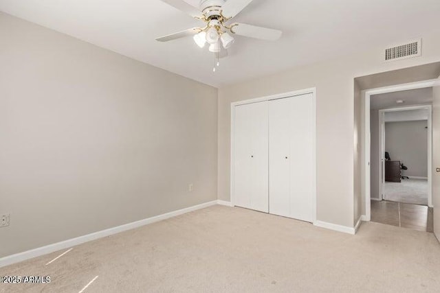 10448 W Caron Dr, Sun City, AZ 85351 - unfurnished bedroom featuring light colored carpet, baseboards, a closet, and a ceiling fan
