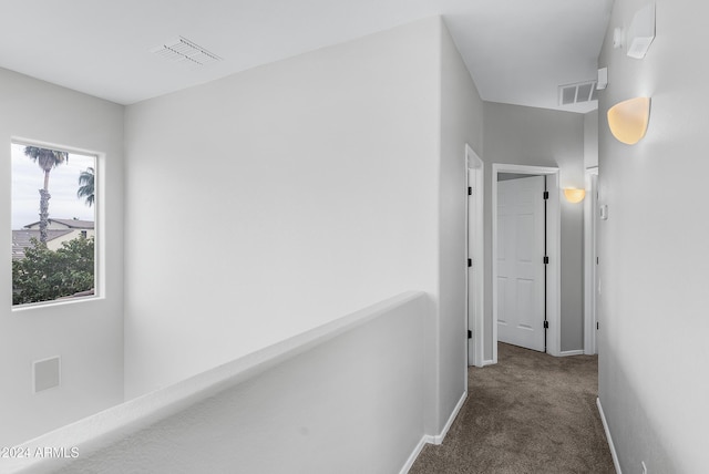 hallway with dark colored carpet