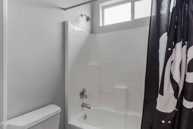 bathroom featuring shower / bath combination with curtain and toilet