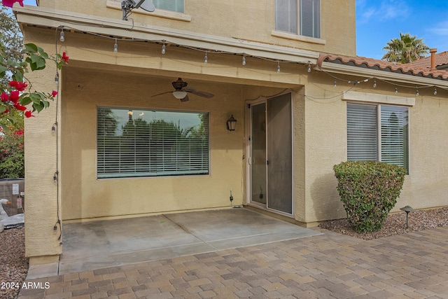 doorway to property with central AC unit, ceiling fan, and a patio