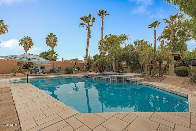 view of pool with an in ground hot tub and a patio