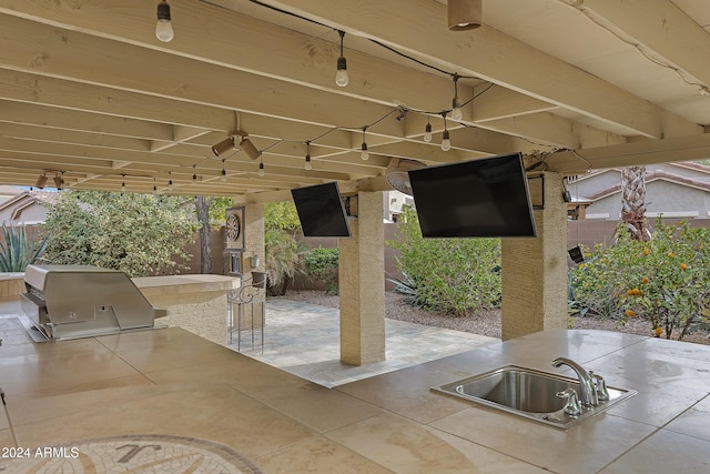 view of patio with area for grilling, ceiling fan, an outdoor wet bar, and an outdoor kitchen