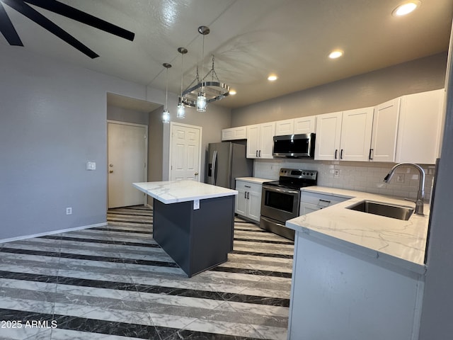 kitchen with a center island, white cabinets, a sink, stainless steel appliances, and decorative backsplash