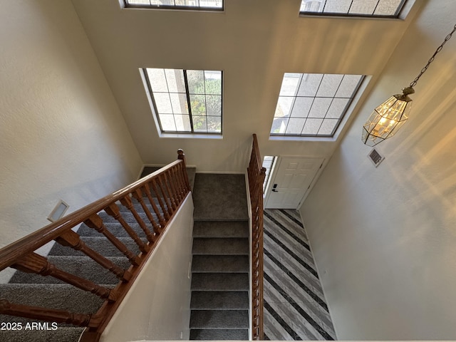stairs with carpet flooring and visible vents