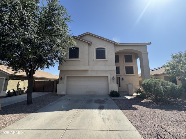view of front of property featuring concrete driveway, an attached garage, fence, and stucco siding