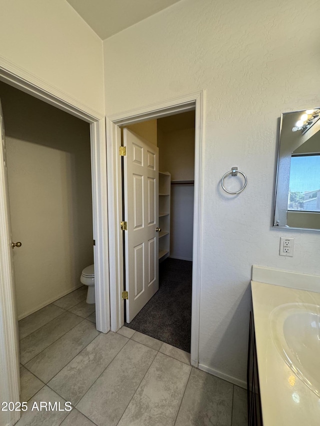 bathroom featuring tile patterned floors, toilet, and vanity