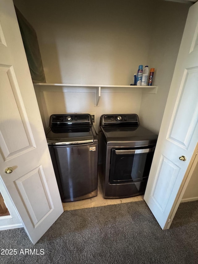 clothes washing area featuring washing machine and dryer, laundry area, and light carpet