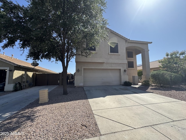 view of front of home with an attached garage, fence, driveway, and stucco siding
