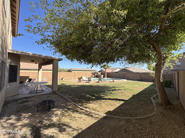 view of yard featuring a patio area, a fenced backyard, a fenced in pool, and an outdoor fire pit