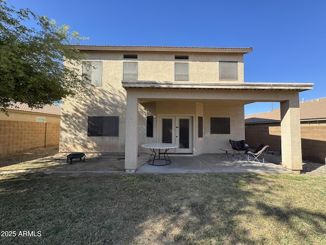back of property featuring french doors, a patio area, stucco siding, and fence