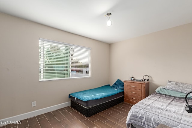 bedroom with dark hardwood / wood-style flooring