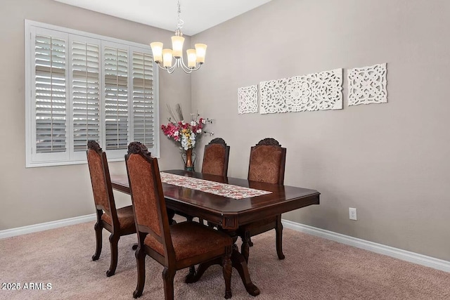 dining space featuring carpet and a chandelier