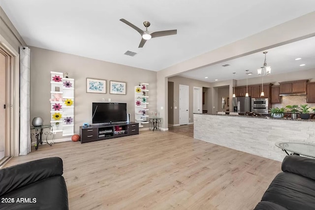 living room featuring ceiling fan and light hardwood / wood-style floors