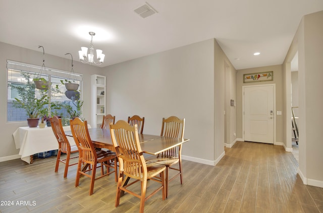 dining area featuring light hardwood / wood-style floors and an inviting chandelier