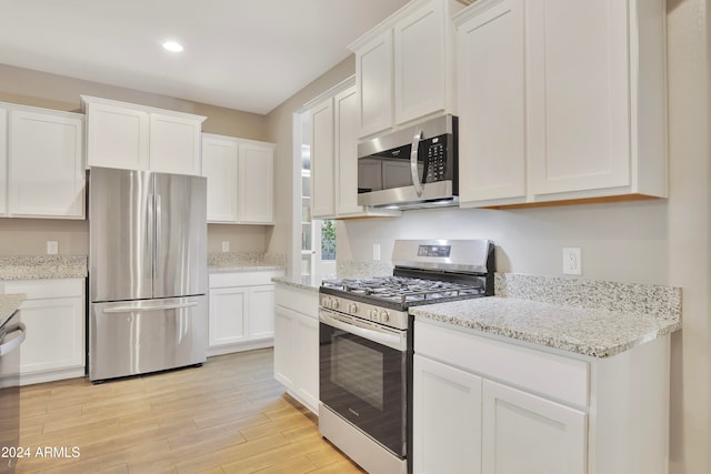 kitchen featuring light stone countertops, white cabinetry, and appliances with stainless steel finishes