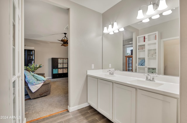 bathroom featuring ceiling fan with notable chandelier and vanity