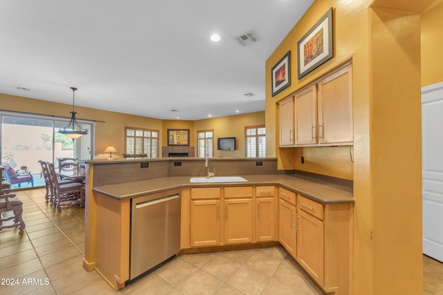 kitchen featuring kitchen peninsula, light brown cabinetry, dishwasher, pendant lighting, and sink