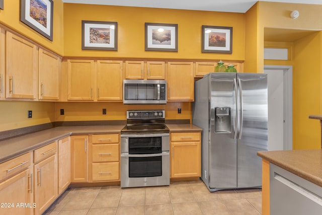 kitchen featuring appliances with stainless steel finishes, light tile patterned flooring, and light brown cabinets