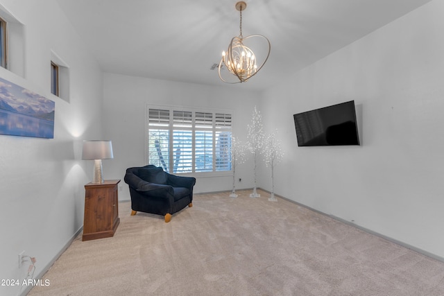 sitting room with light carpet and an inviting chandelier