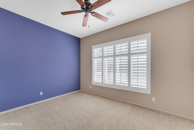 carpeted spare room with ceiling fan