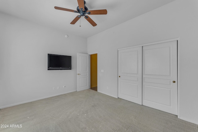 unfurnished bedroom with ceiling fan, a closet, and light carpet