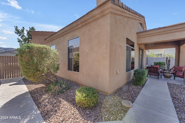 view of side of property with a patio area and an outdoor fire pit